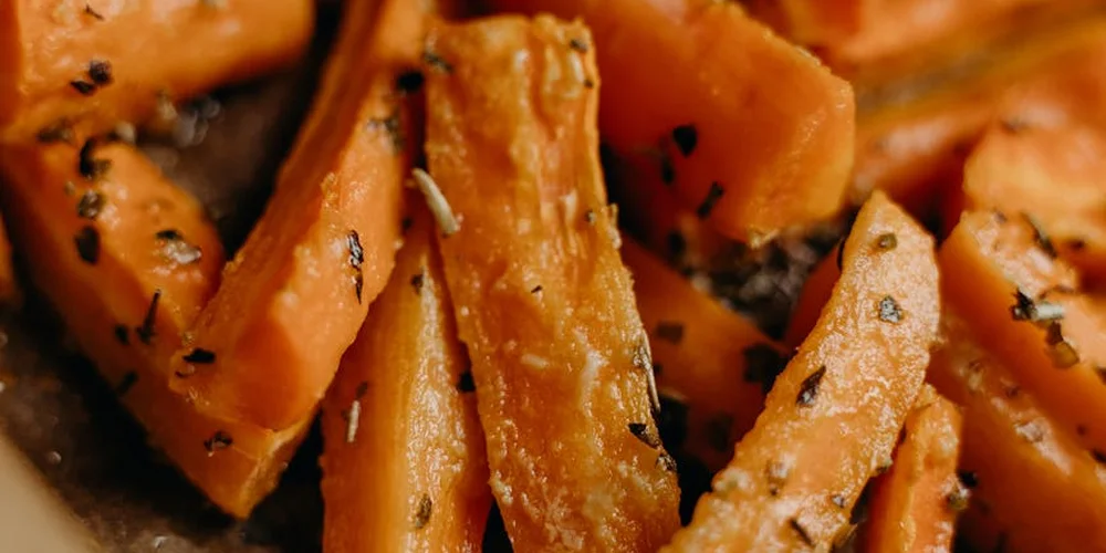 Close-up of roasted carrot sticks with herbs