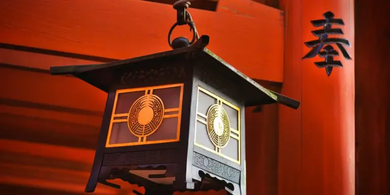 Decorative Japanese lantern hanging in a red-lit setting, with a black kanji character visible in the background.