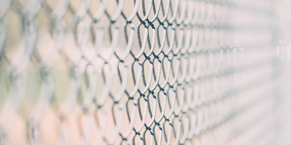 Close-up of a chain-link fence used as a secure barrier for an outdoor turtle enclosure