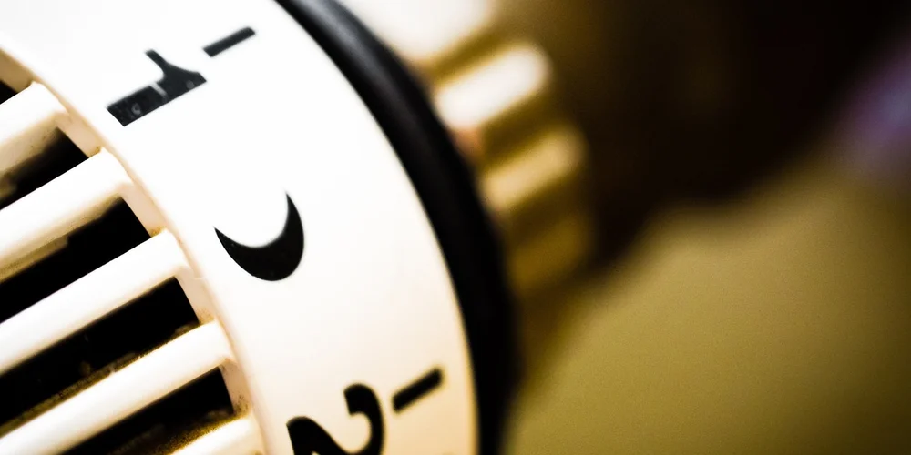 Close-up of a thermostat control knob with a moon icon, illustrating nighttime temperature management for a turtle enclosure.