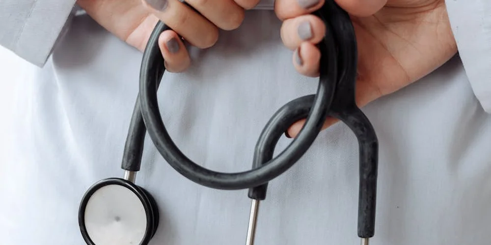 Close-up of a veterinarian's hands holding a stethoscope during a turtle's veterinary checkup