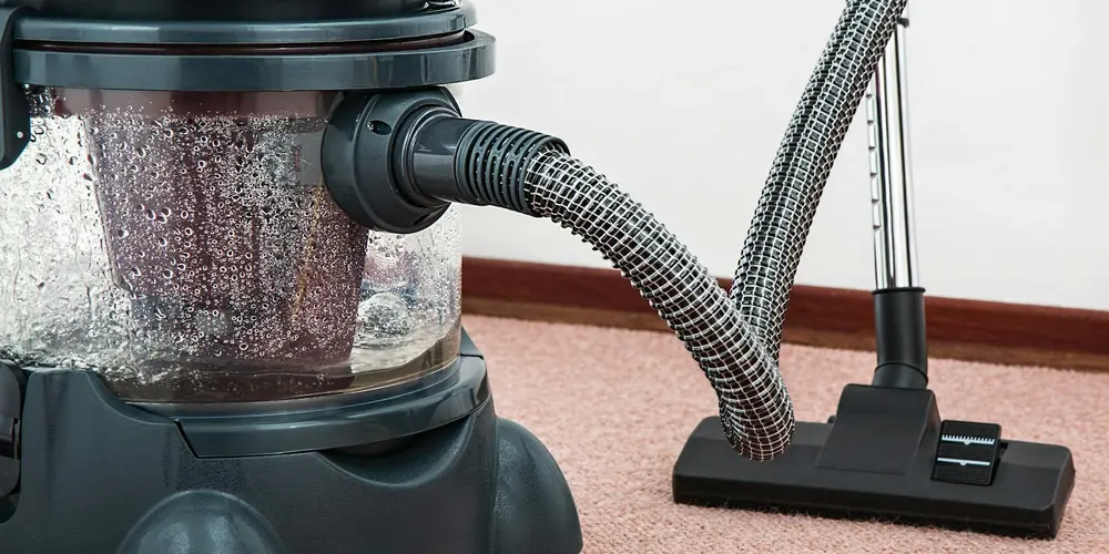 Close-up of a canister filter with flexible hoses attached, used for cleaning and circulating water in a turtle habitat