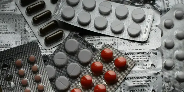 Close-up of blister packs and pills placed on top of a newspaper, illustrating veterinary medications and the theme of turtle health care.