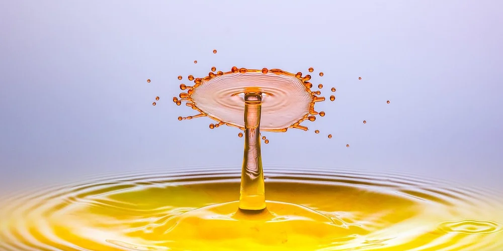 Close-up of a yellow water splash forming a crown above the surface.